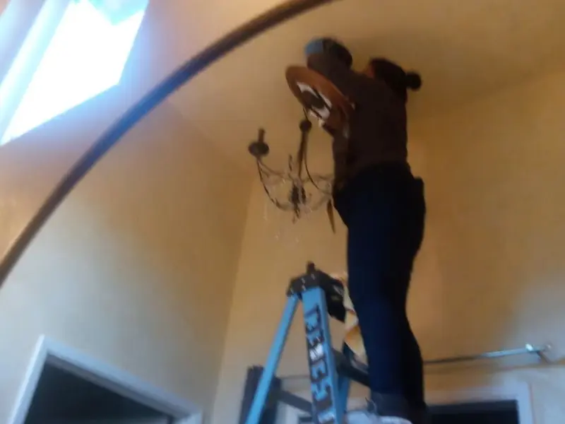 Electrician installing a chandelier in a Wakefield residence